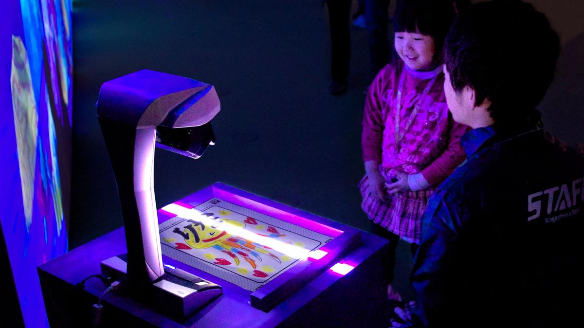 Children draw their own sea creatures in the Sketch Aquarium before scanning them and watching them come to life before their eyes / teamLab