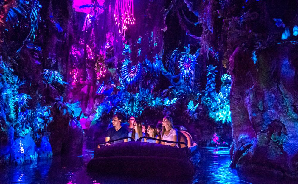 Guests take a reed boat through a bioluminescent rainforest in the Na’vi River Journey / PHOTO: DISNEY 