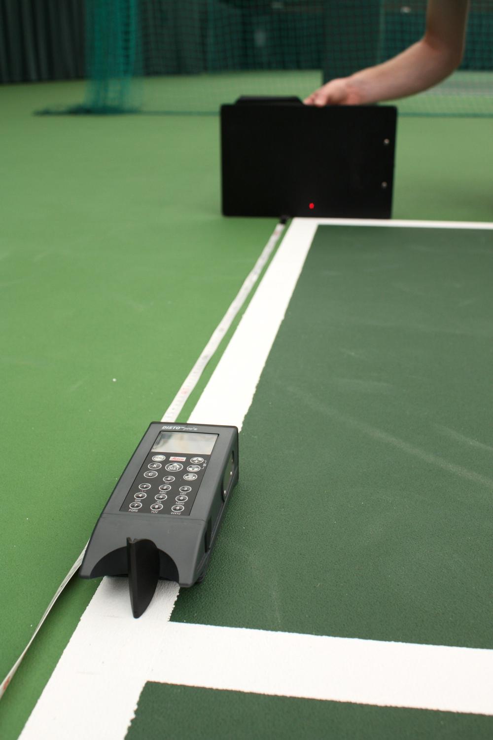 An evenness test measures the size of bumps or dips in the tennis court surface, using a straight line edge