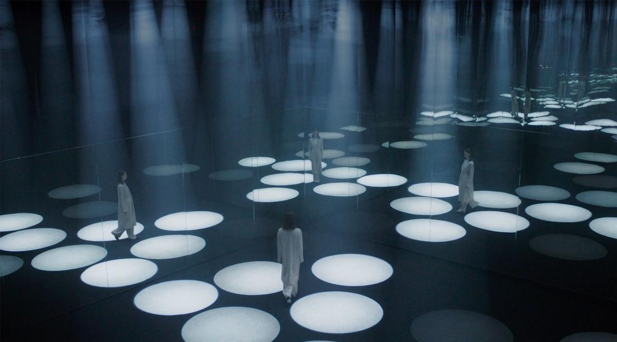 A darkened space is illuminated by towering cones of light that respond to visitors’ movement / COS