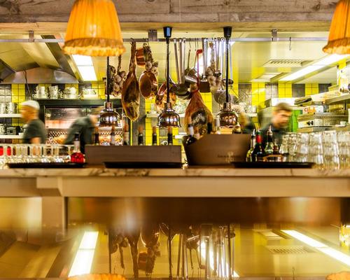 Yellow tiles and orange lampshades add to the colourful effect / Philippe Starck