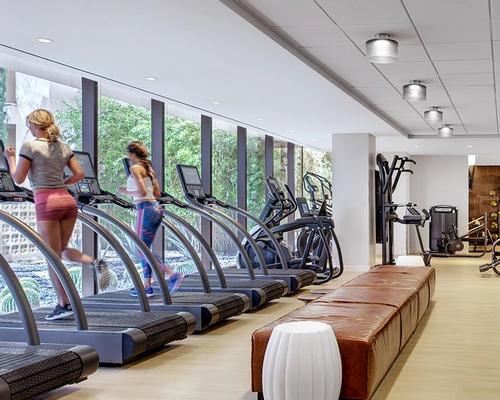 The gym features a comprehensive fitness area with Woodway treadmills and Matrix fitness equipment