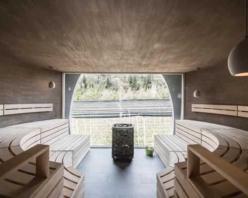 The earth-coloured concrete walls pursue the lines of the wooden slats of the sauna benches / NoA*