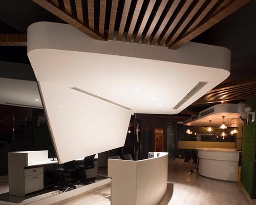 Asymmetrical white volumes cover the gym's ceilings / Purnesh Dev Nikhanj