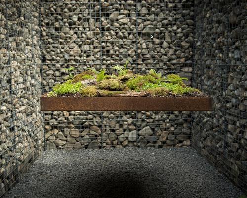 A levitating green platform is suspended in the Le Caveau garden / International Garden Festival