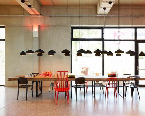 Bare walls and raw materials are fused with ambient lighting and colourful props / Moxy Berlin