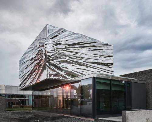 The crinkled shining cube is now the main visual point of the building 