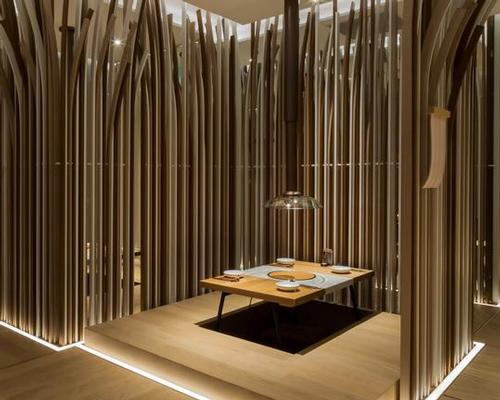 The semi-enclosed dining spaces are divided by screens of vertical, curving wood strips / Golucci International