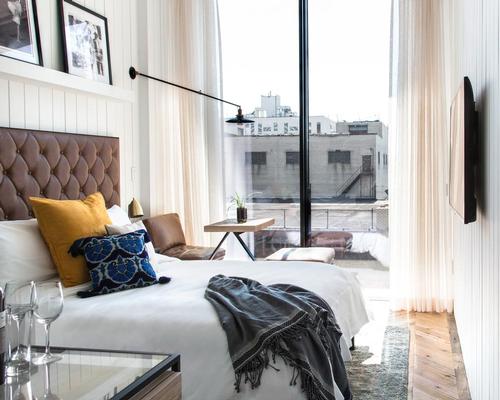 Inside, the design schemes vary from white-washed timber walls to deep grey distressed finishes with bespoke leather, brass, marble, and textured details / The Williamsburg Hotel