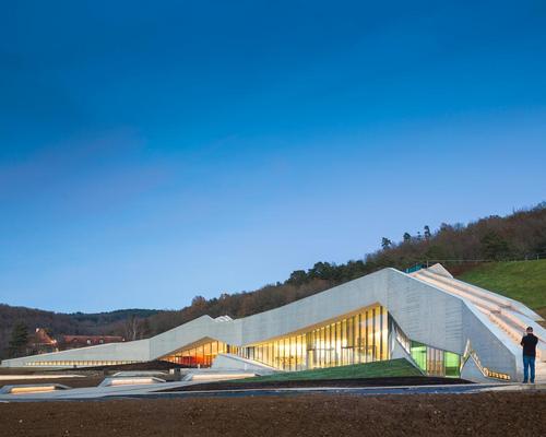 The form of the centre merges with Lascaux hill and the forest beyond / Boegly + Grazia