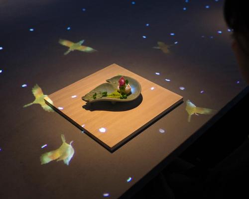 A bird painted on a ceramic dish is seemingly released and flies to perch on the branch of a
tree / teamLab