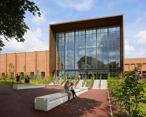 A glazed double-height façade provides “an invitational glimpse” of the swimming pool inside / Hufton + Crow