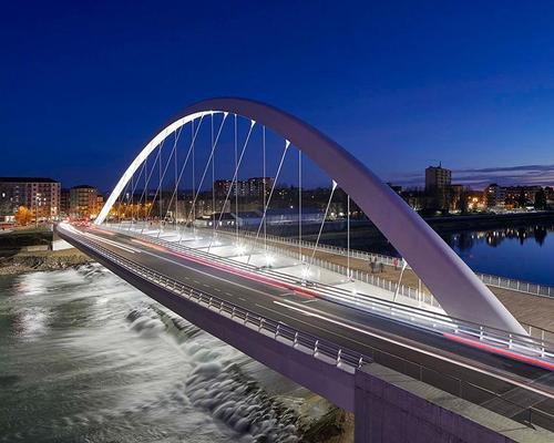 The 185m (606ft)-ling single span bridge is formed of precast-concrete and painted-steel / Hufton + Crow