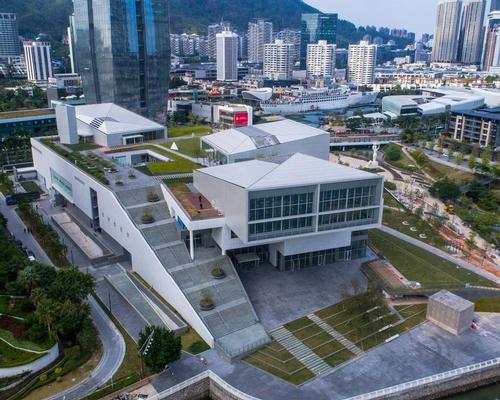 The Sea World Culture and Arts Center (SWCAC), located in Shenzhen Bay, is formed of three white cantilevered volumes atop a deconstructed plinth / Design Society
