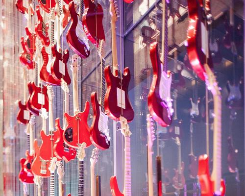 A wall of 160 red guitars stands behind the reception desk / Nirut Benjabanpot