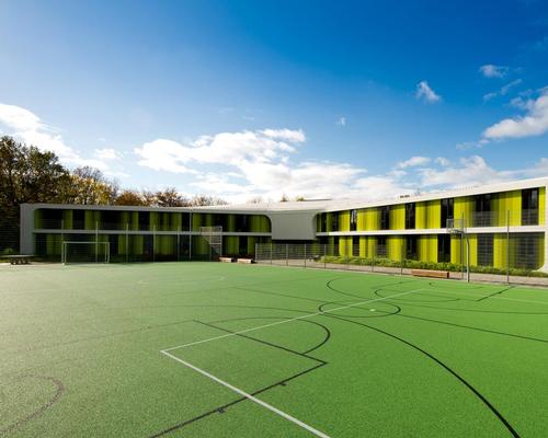 Interior and exterior spaces interweave across two floors, offering expansive views and multiple accessible openings to the sports fields and garden