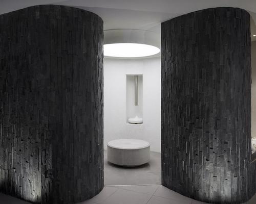 Sat underneath the hotel, guests descend in front of a wall of timber and stone into the spa via an elevator
