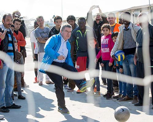 IOC president Thomas Bach plays football with refugees in Athens / International Olympic Committee