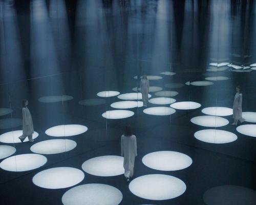 A darkened space is illuminated by towering cones of light that respond to visitors’ movement / COS