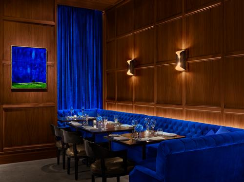 The restaurant's interior spaces are furnished with electric blue and emerald green banquettes. / Photo by Nicholas Koenig