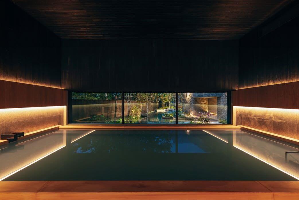 The indoor hot thermal pool are lined with aromatic wood and has large picture windows / Hoshinoya