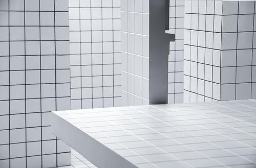The floors, walls, and counter are covered in a white, tiled grid graphi / Unknown Works