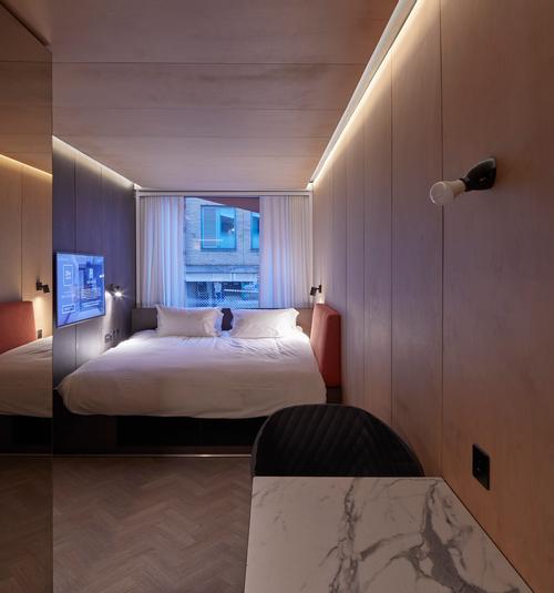 TVs are mounted along one side of each bed with a cushioned backrest opposite / Edmund Sumner