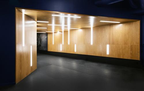 The workout space employs a warm, dark pallette juxtaposed with bright lighting and highlights / Rafael Soldi