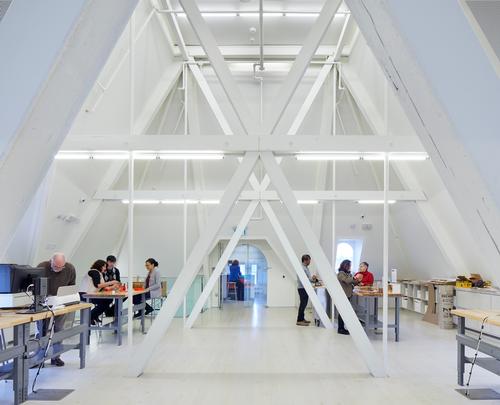 A makerspace in the peaked attic is braced by steel trusses / Tom Arban