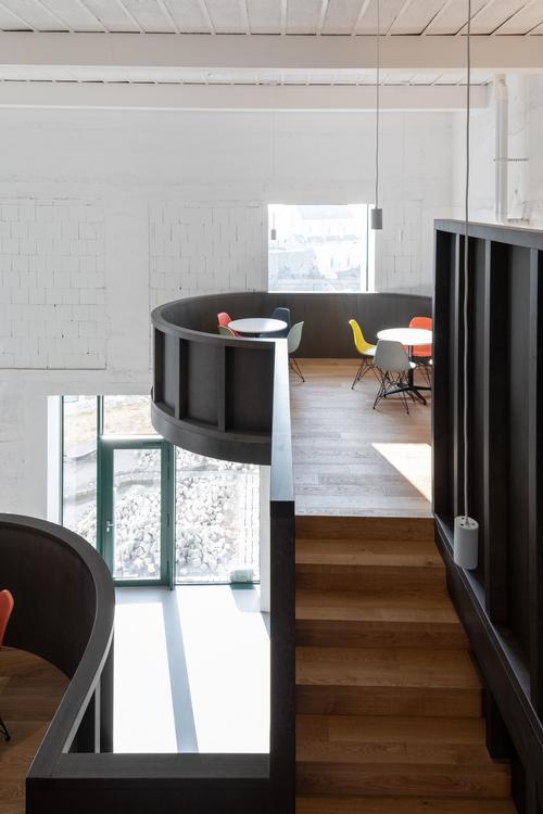 The interior of the more recent technical building has been divided by curved wooden volumes / Alex Shoots Buildings