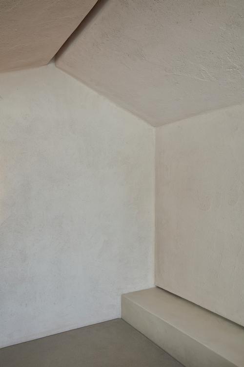 Lime-finished banquettes run along the base of the walls to provide seating / Oculis Project