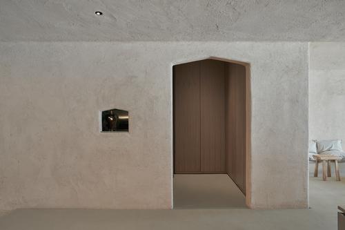 Clay walls are left plain, recalling the utilitarian nature of a horse stall / Oculis Project