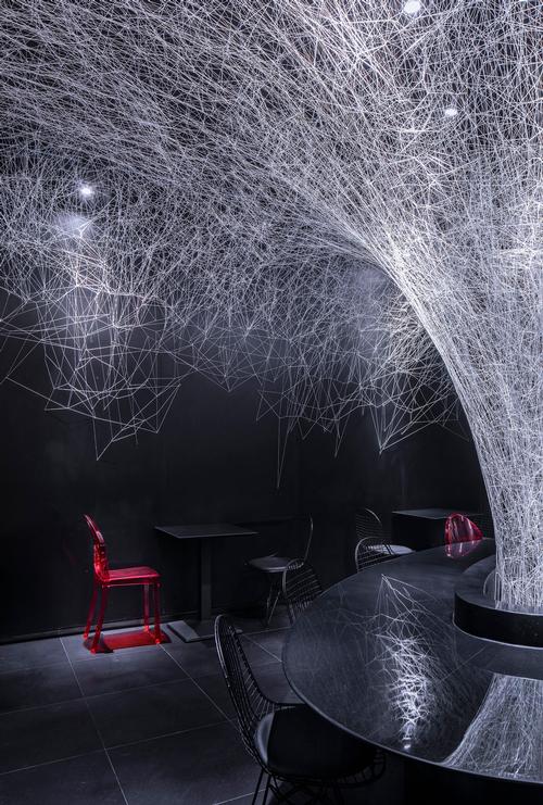 The sculpture is highlighted against the restaurant's black walls / Jin Weiqi