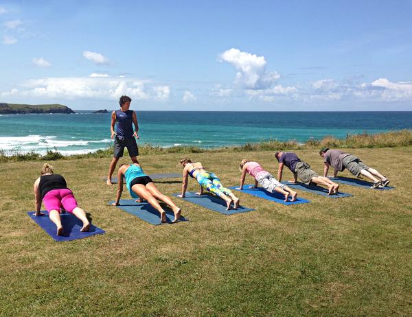 A surf yoga class overlooking the beach in Cornwall