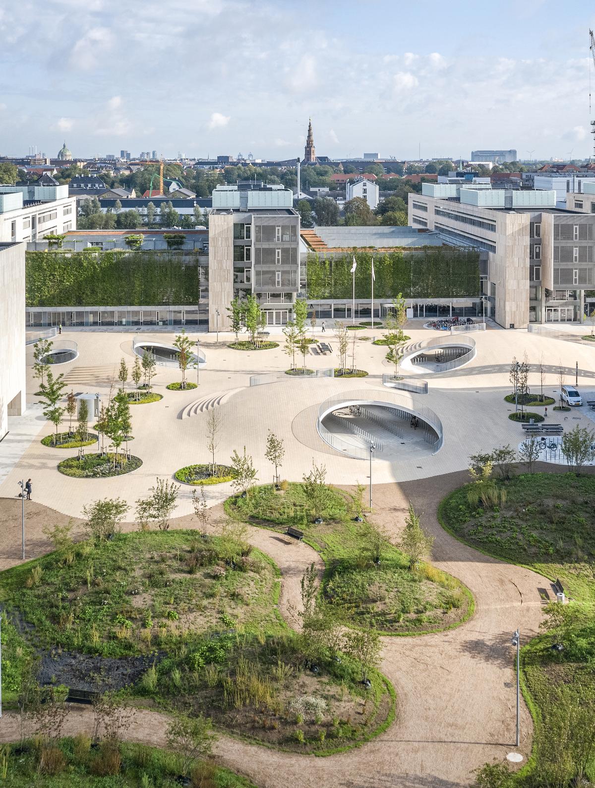 The square combines spaces for sitting and meeting with landscaped beds for trees and plants / Rasmus Hjortshøj - COAST