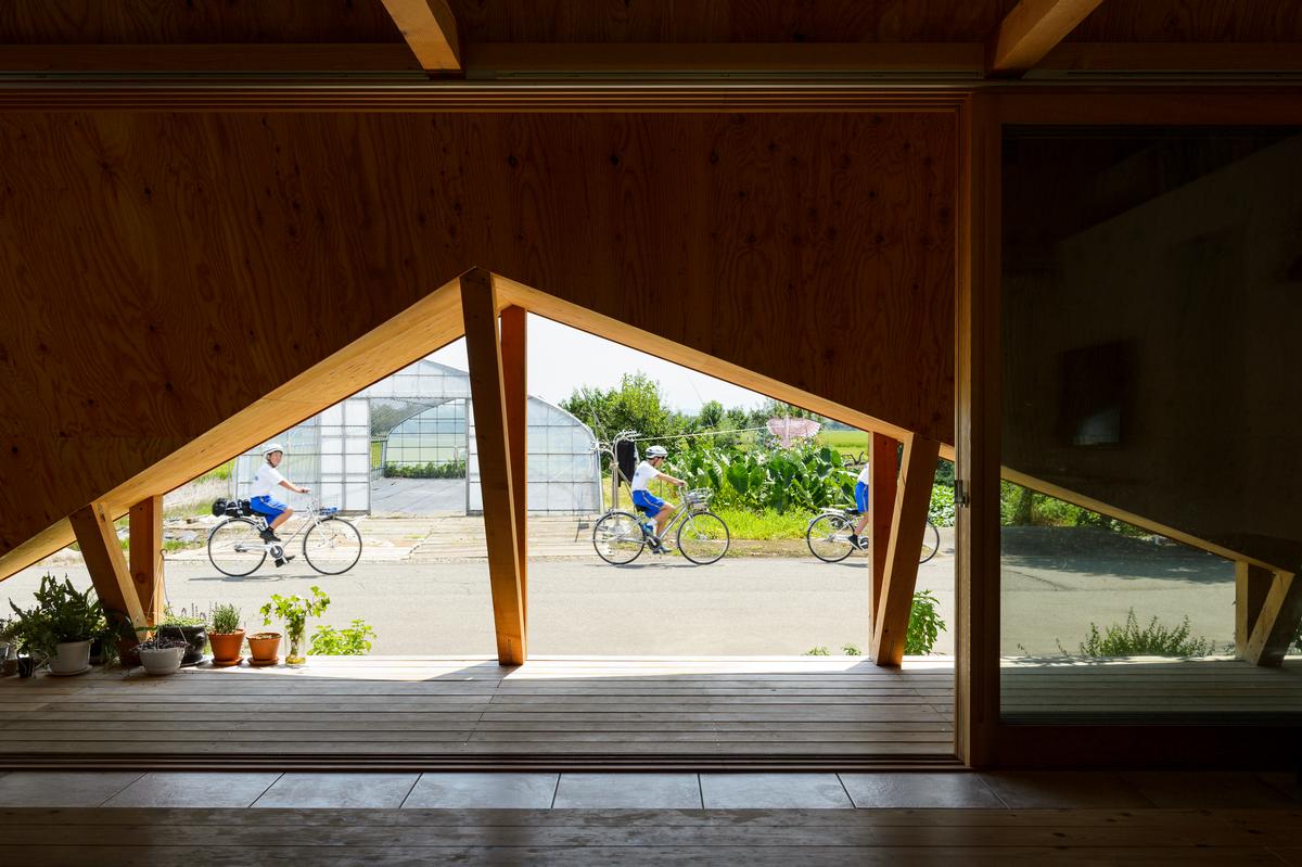 The origami-like folded additions provide covered indoor-outdoor spaces / Isamu Murai