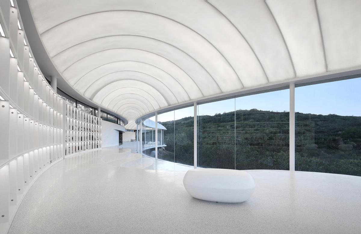 The thin roof membrane allows additional natural light into the space during the day / zystudio